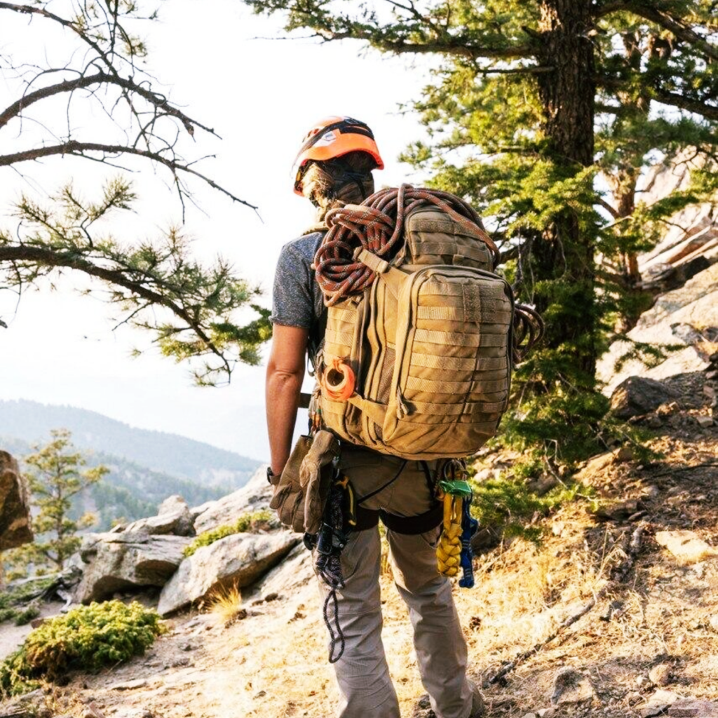 The 5.11 RUSH 72 2.0 Backpack 55L carrying climbing and outdoor gear on a rugged mountain trail