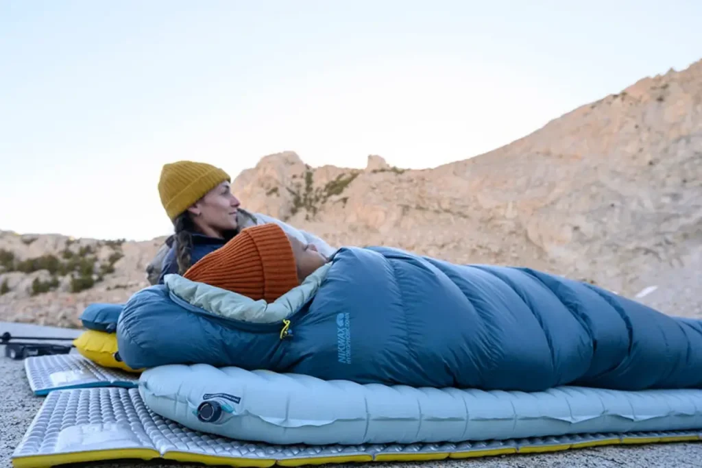 Therm-a-Rest RidgeRest sleeping pad used as a base layer under an inflatable pad during an outdoor mountain camp setup