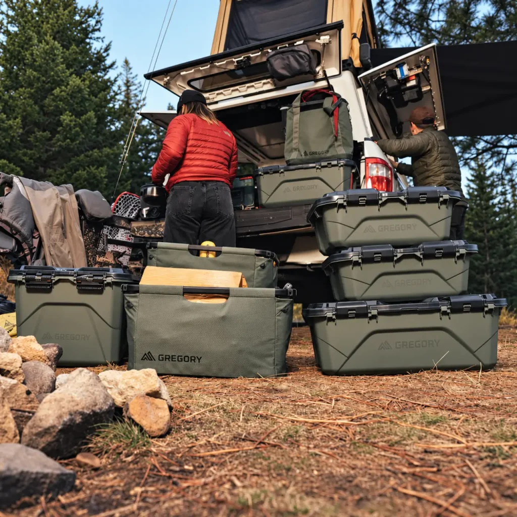 Gregory storage boxes and camping organizers arranged around an overland vehicle for organized car camping gear storage.